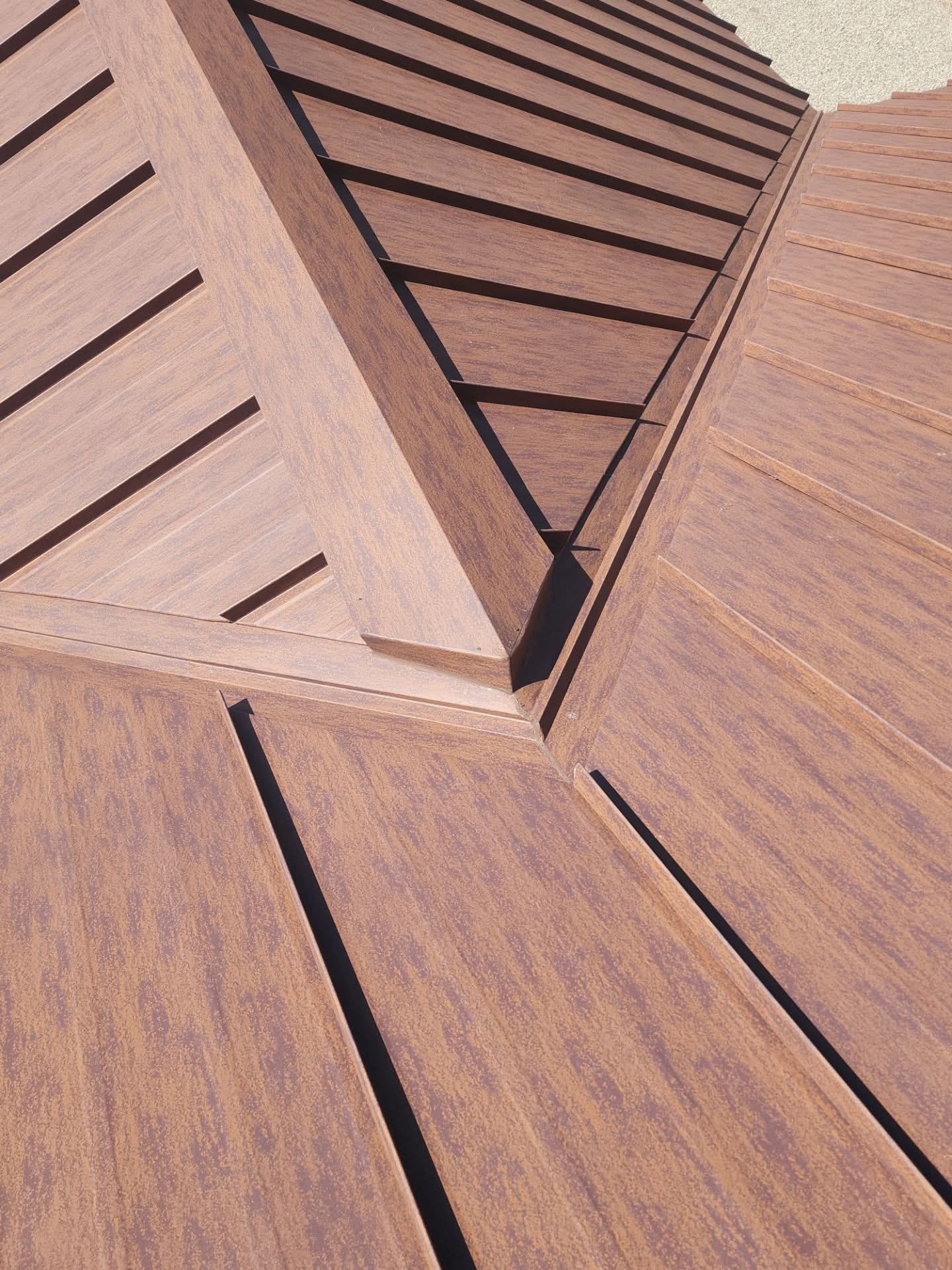 Close-up of wooden panels with slats and grooves, arranged in a geometric pattern, viewed from below.
