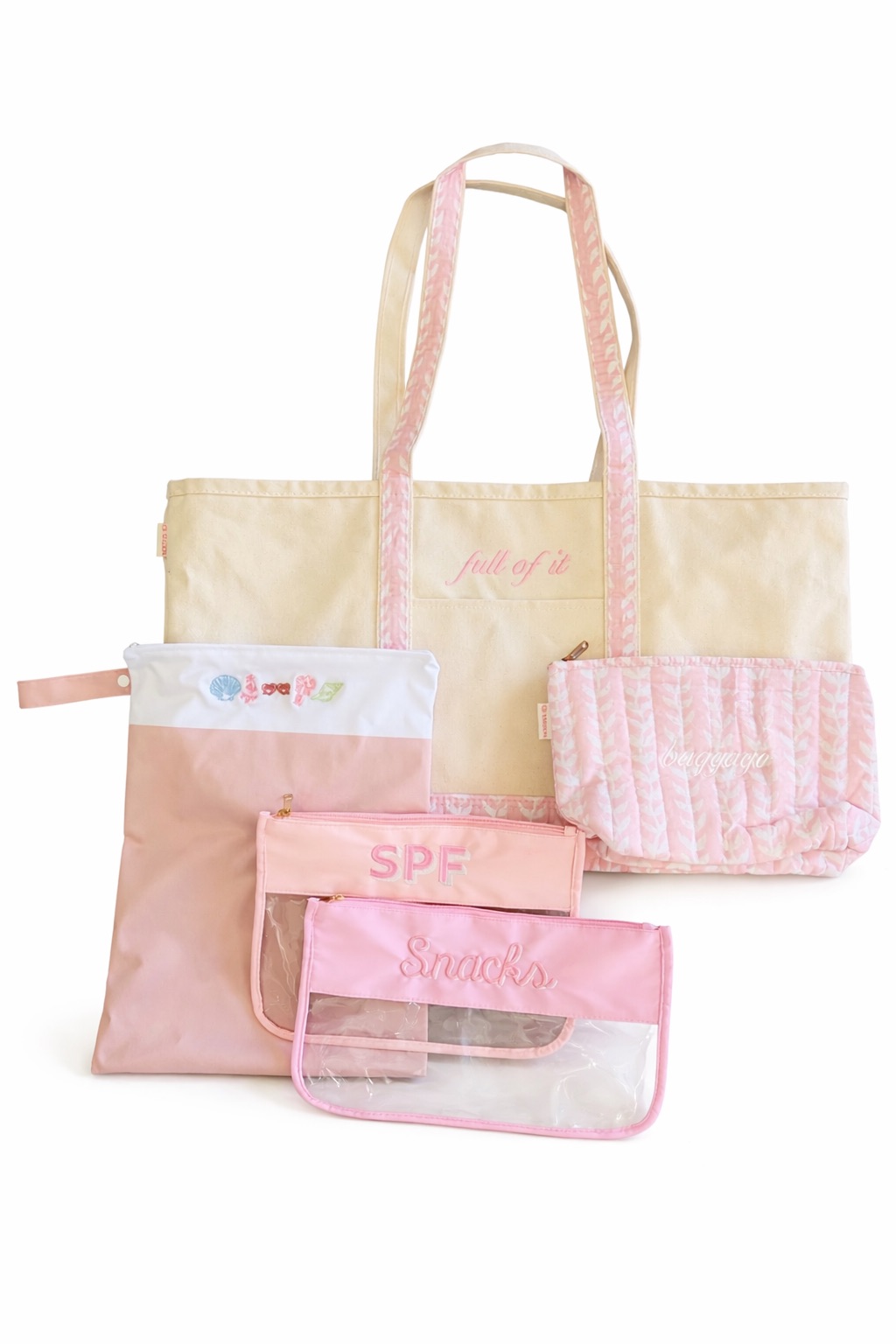 Collection of five pastel-colored bags and pouches, including a large tote, small pouches, and a pink knitted item, on a white background.
