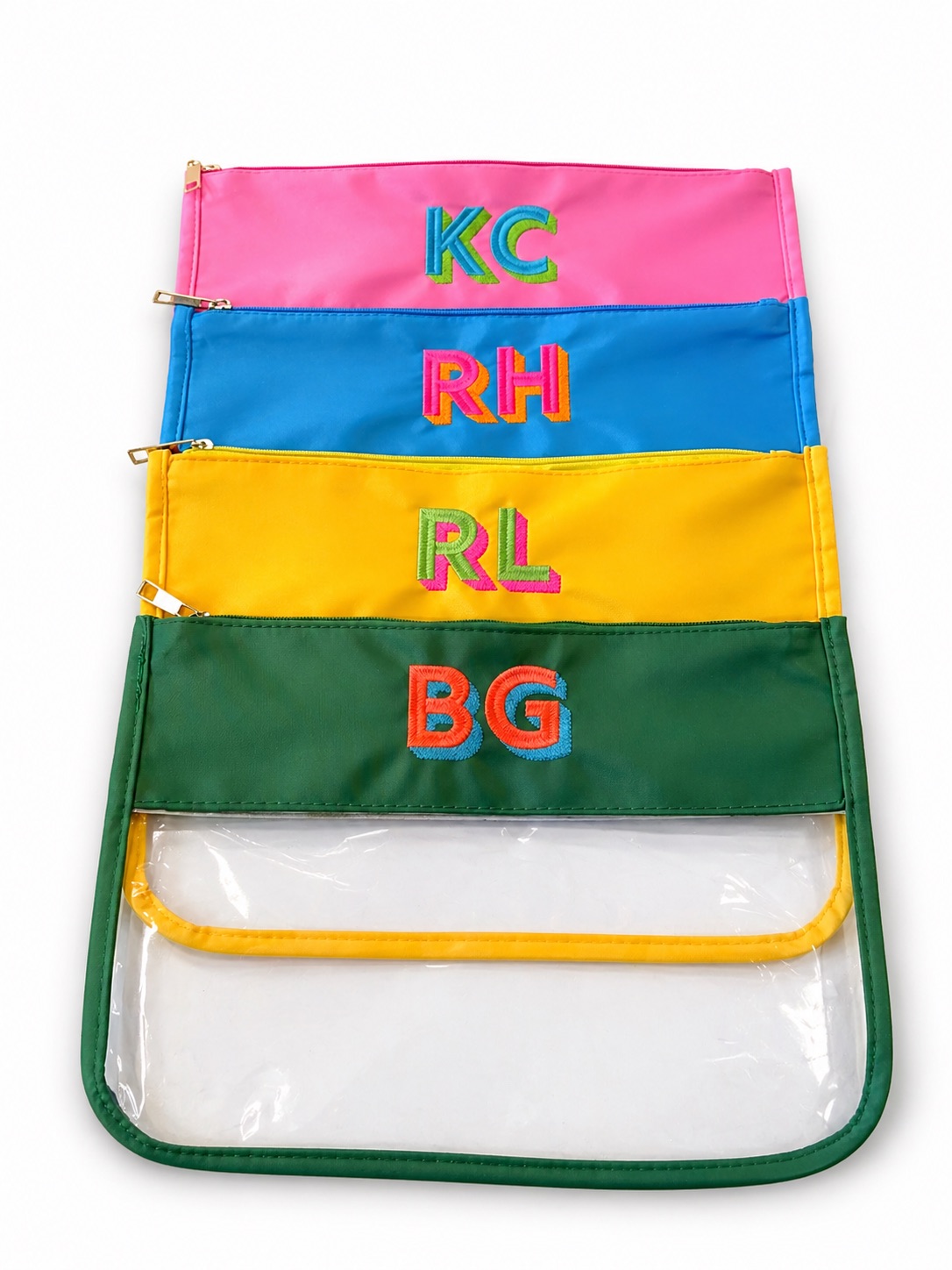 Five colorful zippered pouches stacked vertically, each with initials: KC, RH, RL, BG, and a transparent pouch at the bottom.